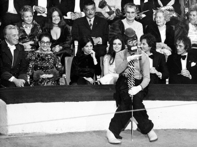 American comedian Jerry Lewis performs as a clown at the 38th Gala de L'Union des Artistes at the Cirque d'Hiver in Paris, France, April 24, 1971. Watching in the background are, from left, Italian film director and producer Vittorio de Sicca, opera singer Maria Callas, unidentified woman, Italian actress Gigliola Cinmetti and French singer Hughes Aufray. 