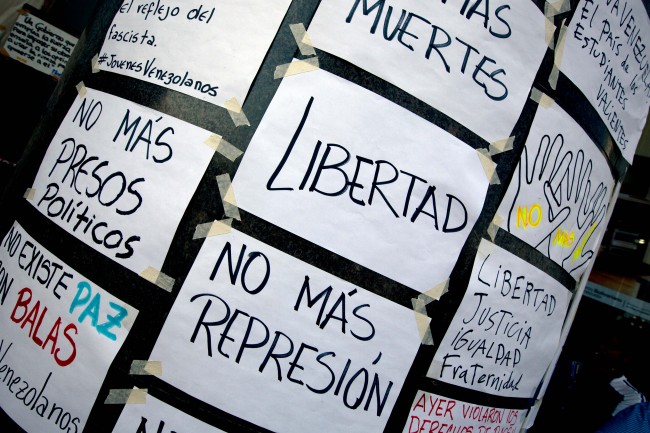 Hand made posters are pasted on the wall outside of United Nations office in Caracas, Venezuela, Tuesday, March 25, 2014. The posters read in Spanish "Freedom", "No more repression", "No more political prisoners", "No more killed". A large group of protesting anti-government students have camped in front of the office of the United Nations asking it to come and observe the situation, as VenezuelaÂs bloody political standoff heads into its third month. The decision to pitch tents on the concrete sidewalk along one of CaracasÂ busiest, smog-filled streets comes as foreign ministers from several South American nations arrive Tuesday to lend support to President Nicolas MaduroÂs efforts at reconciliation with his opponents