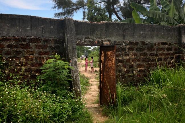 ** ONE IN A SERIES OF 15 PHOTOS BY AP PHOTOGRAPHER DAVID GUTTENFELDER WHICH WON THE APME PHOTO CONTEST FEATURE CATEGORY--FILE **Two young girls play in their village, seen through a door in the wall of the Danang airbase in Danang, Vietnam, in this May 21, 2007, file photo. More than 30 years after the Vietnam War ended, the poisonous legacy of Agent Orange has emerged anew with a scientific study that has found extraordinarily high levels of health-threatening contamination at the former U.S. air base at Danang.