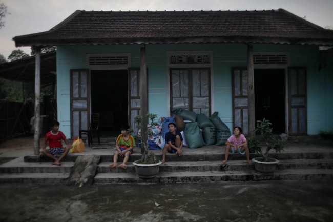 In this photo taken on Oct. 4, 2009, Vietnamese siblings, from left, Tran van Hoang, Tran Van Lam, Tran Van Luan and Tran Thi Luy, sit on the front porch of their family home in the village of Cam Tuyen, Vietnam. The siblings were born with profound physical and mental disabilities that the family, and local officials say, were caused by their parents' exposure to the chemical dioxin in the defoliant Agent Orange.