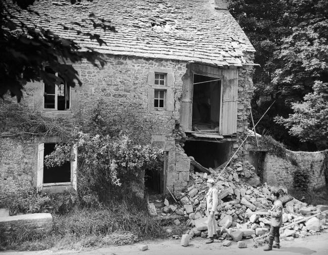 Two French civilians look over the wrecked birthplace of the French painter, Jean-Francois Millet in France on August 28, 1944. The house was situated at Gruchy near Greville, which was one of the most heavily fortified regions on the Normandy coast and the scene of many bitter battles before it was liberated by the Americans. Many Nazi soldiers were taken prisoner near here. (AP Photo/Lawrence Riordan)