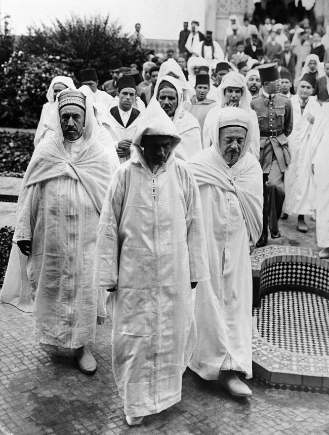 The Sultan of Morocco, Sidi Mohamed, who is on a visit to Paris, attended Friday ritual prayers at the mosque there, accompanied by believers from North Africa. The Sultan of Morocco, centre, leaving the Paris mosque with Si Saddour Ben Ghabri, right, Director of the Franco-Musulman Institute, on July 16, 1937. (AP Photo)