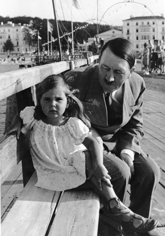 circa 1935:  German dictator Adolf Hitler sitting on a bench with Helga Goebbels, daughter of Nazi propagandist Paul Joseph Goebbels.  (Photo by Fox Photos/Getty Images)